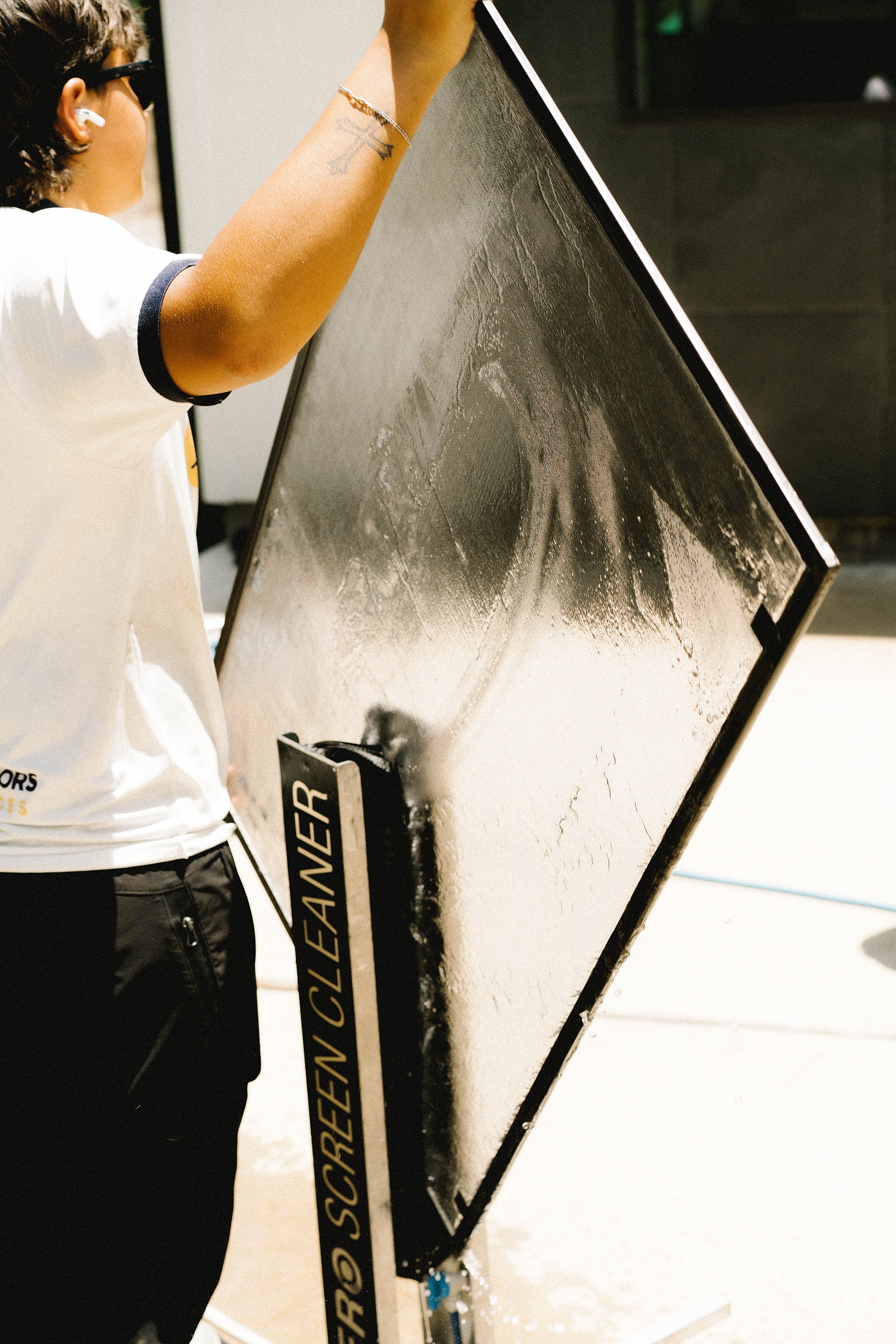Window Warriors technician cleaning a window screen with a dedicated screen cleaning tool