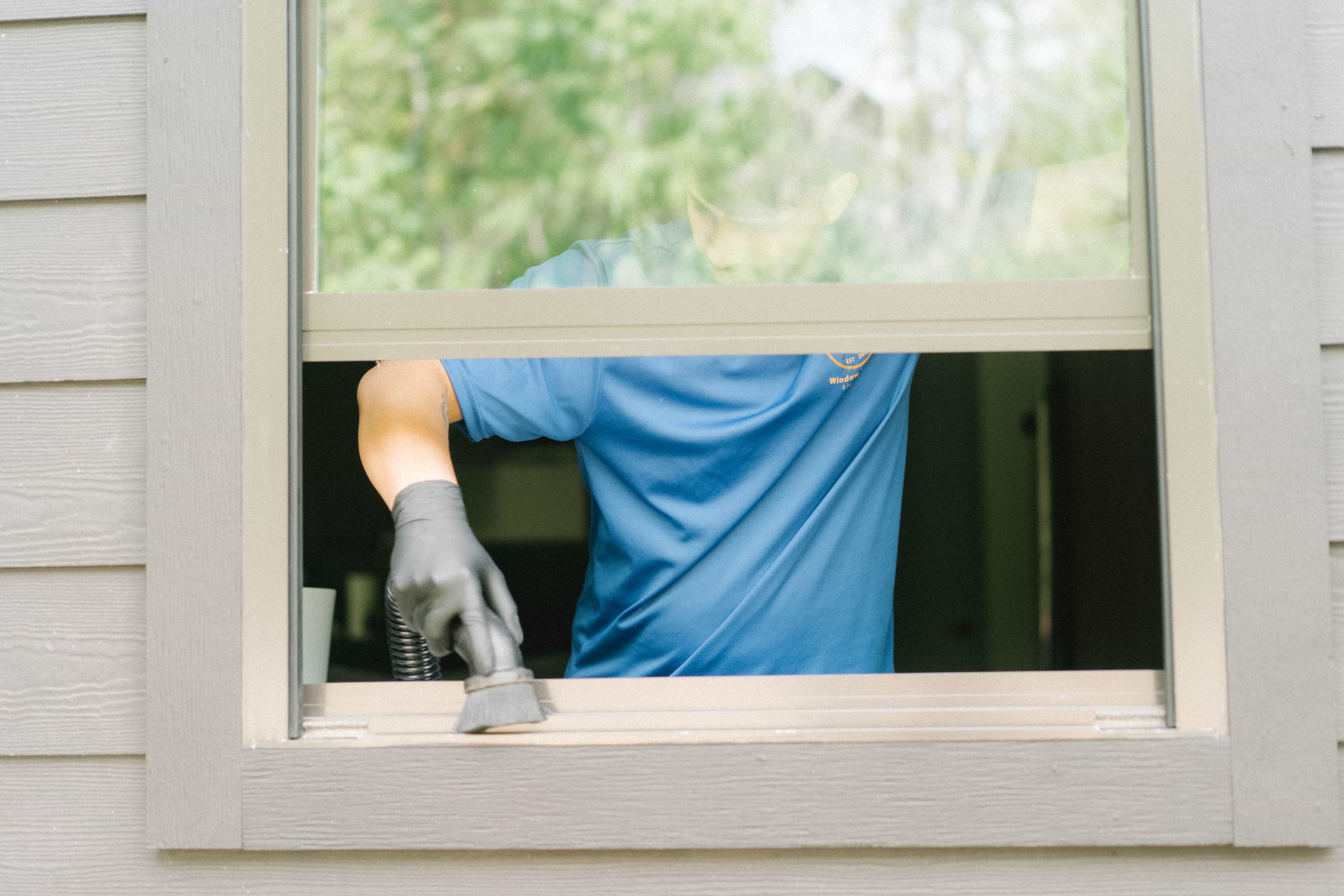 Technician vacuuming a window track